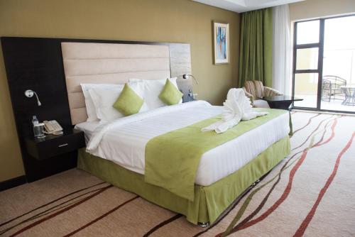 布兰太尔Crossroads Hotel Blantyre的酒店客房带一张大床,带绿色窗帘