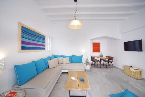 米克诺斯城Mykonos Town Suites的客厅配有蓝色的沙发和桌子
