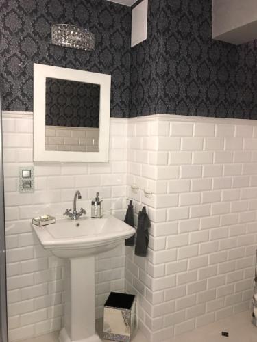波兹南Marii Konopnickiej 20的浴室设有白色水槽和黑色墙壁