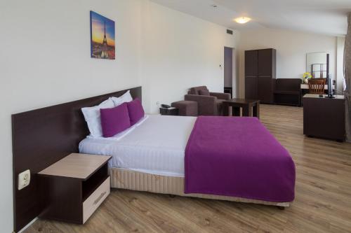 克尔贾利卡尔蒂亚丽酒店的一间卧室配有一张带紫色床单的大床