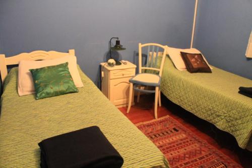 布宜诺斯艾利斯Mariel B&B的一间卧室配有两张单人床和一把椅子