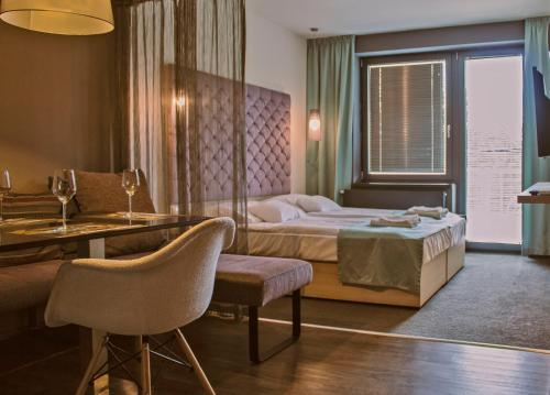 萨尔瓦尔Orion Apartman的酒店客房带一张床、一张桌子和椅子