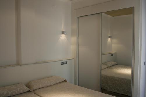 贝尼多姆森博宫公寓式酒店的一间卧室配有两张床和镜子