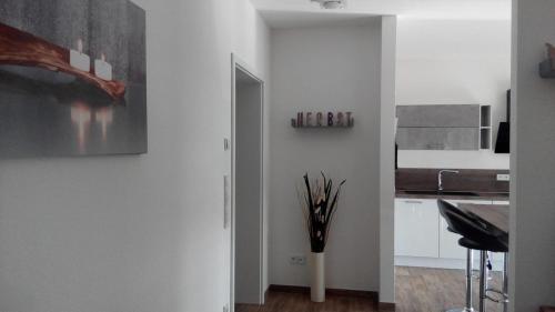 诺费尔登Im Hirzenbruch 1的厨房设有白色的墙壁和一个带棍子的花瓶
