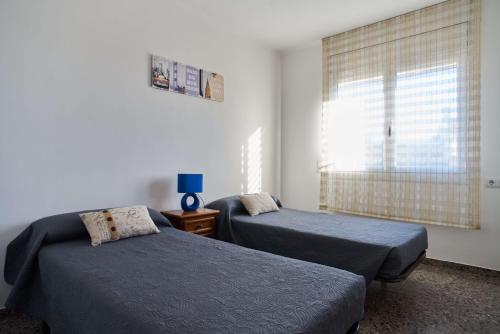 曼雷沙Manresa Apartamentos Turísticos的一间卧室设有两张床和窗户。