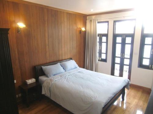 曼谷皇家查亭度假村酒店的一间卧室配有一张带白色床单的床和一扇窗户。