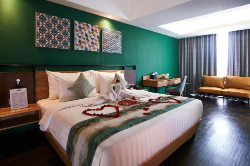 班达亚齐基里阿德姆拉雅阿策酒店的一间卧室设有一张大床和绿色的墙壁