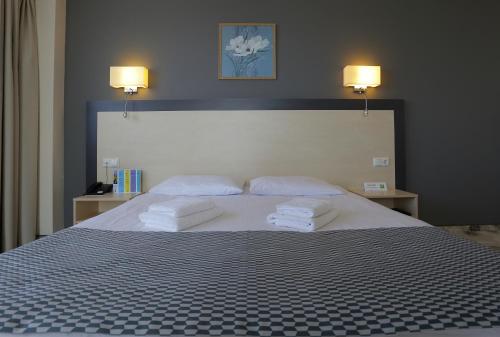 克莱佩达Aurora Hotel Klaipeda的一间卧室配有一张大床和两条毛巾