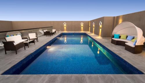 达曼Boudl Al Corniche的一座配有桌椅的酒店游泳池
