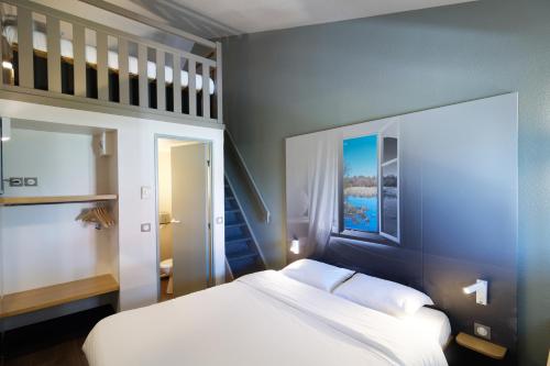 DéolsB&B HOTEL CHATEAUROUX Aéroport的卧室配有白色的床和楼梯。