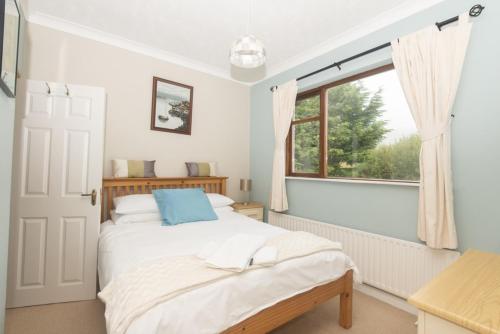 肯梅尔Poppyfield House, Kenmare的一间卧室设有一张床和一个窗口