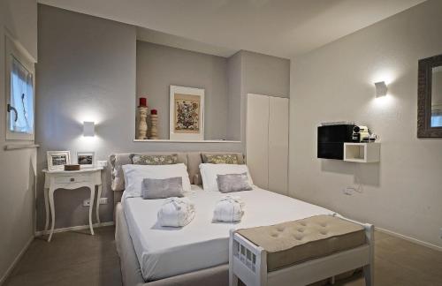 佩斯基耶拉德加达Riviera Carducci Rooms的卧室配有白色的床和电视