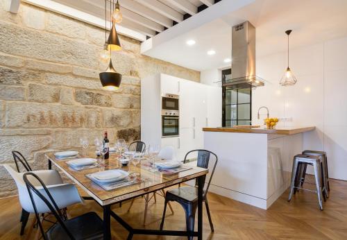 庞特维德拉Verdura Suites ArchSense Apartments的厨房以及带桌椅的用餐室。