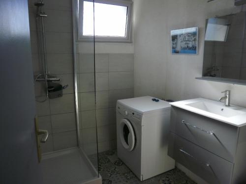 韦尔内莱班la Catalane的一间带洗衣机和水槽的浴室