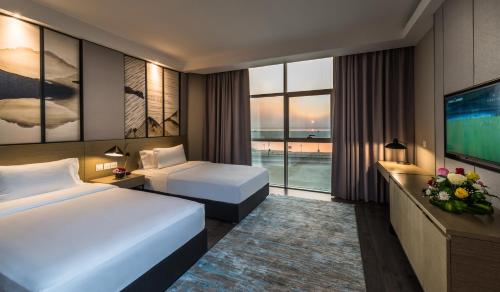 达曼Boudl Al Corniche的酒店客房设有两张床和一台平面电视。