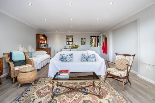 赫曼努斯Protea & Pincushion Cottages的一间带两张床的卧室和一间客厅