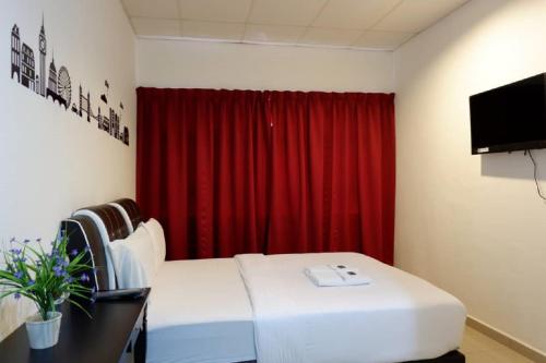 关丹Hotel Tai Wah的一间设有床铺和红色窗帘的房间