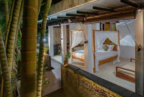 坎古昂吉赛堡酒店的卧室设有两张床,位于棕榈树阳台