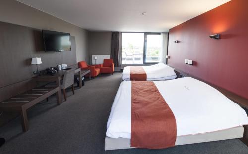 特尔菲伦特尔菲伦赖斯特丽酒店的酒店客房带两张床和一张桌子以及椅子。