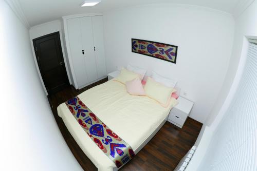 撒马尔罕Apartment on Registon Kochasi的小卧室配有带白色床单和粉红色枕头的床