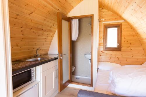 VillierstownBlackwater Eco Pods的一间带水槽的浴室和一张位于客房内的床