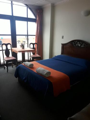 波托西图克斯拉皇家金堡旅馆的一间卧室配有一张床、一张桌子和一个窗户。