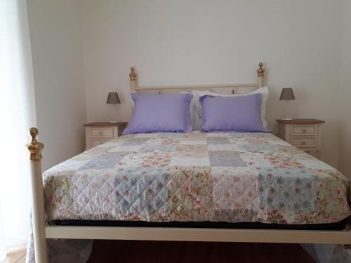 里斯本Crisapartment的一间卧室配有一张带紫色枕头的床