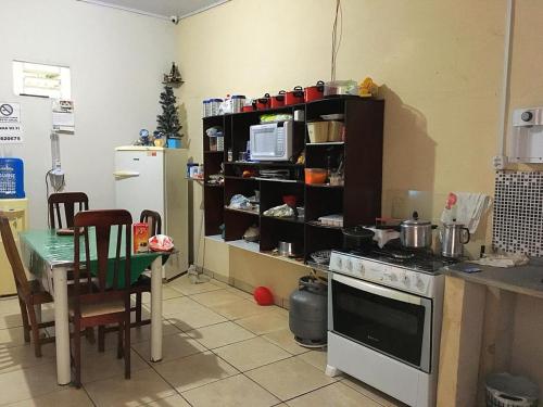 库亚巴Pousada CPA的厨房配有炉灶、桌子和微波炉