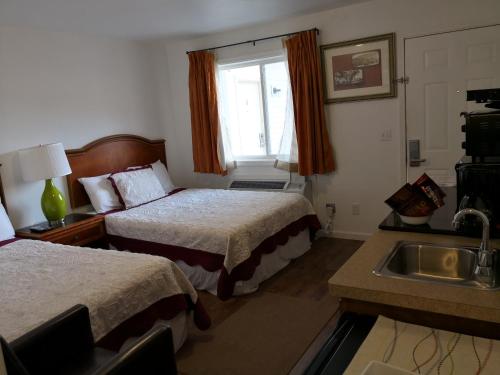 MilfordApple Inn and Suites Cooperstown Area的酒店客房设有两张床和盥洗盆