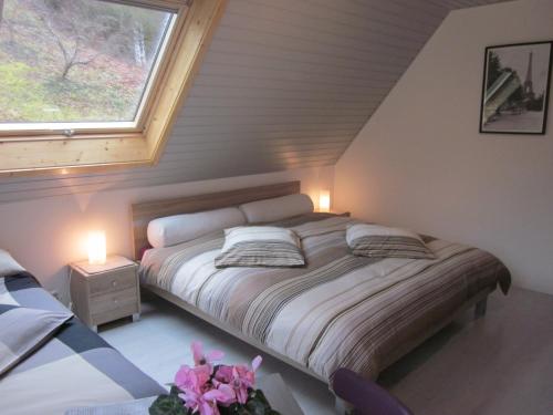 Saint-MartinChambres d'hôtes "Au Val Séjour"的一间卧室配有一张带两盏灯的床和一扇窗户。