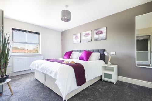 米德尔斯伯勒James Cook's Retreat的一间卧室配有一张带紫色枕头的大床