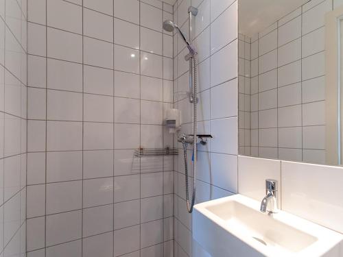 亨宁斯韦尔Fast Hotel Henningsvær的白色瓷砖浴室设有水槽和淋浴