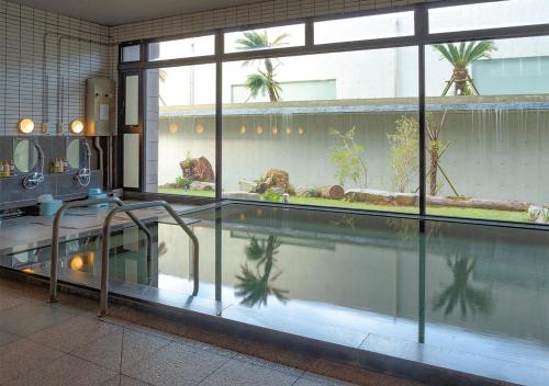 屋久岛THE HOTEL YAKUSHIMA ocean & forest的一座带大窗户的建筑中的游泳池