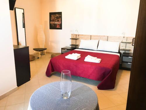 圣埃拉莫因科莱Suite Home La Chianca的一间卧室配有一张带红色床罩和桌子的床。