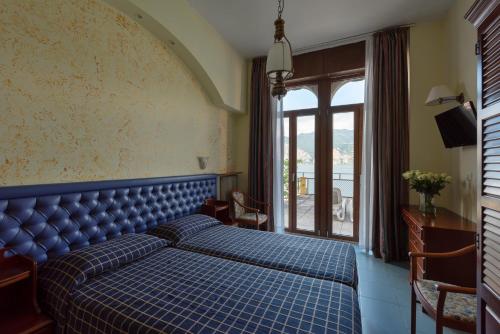 马尔切西内马切尔西涅酒店的一间卧室设有蓝色的床和窗户。