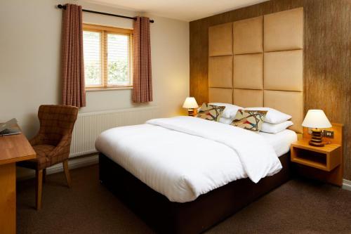 威瑞格林汽车旅馆，利比豪尔乡村的一间卧室配有一张床、一张桌子和一把椅子