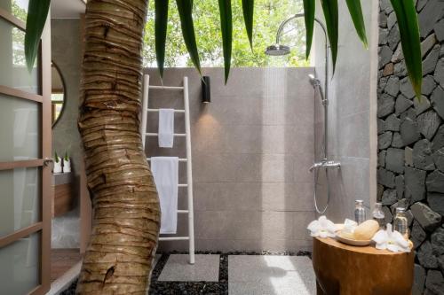 蔻立The Sarojin的浴室设有棕榈树淋浴。