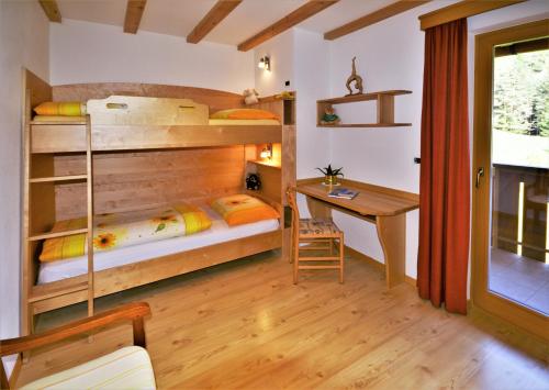 奥蒂塞伊Apartment Larjëi的小房间设有双层床和书桌