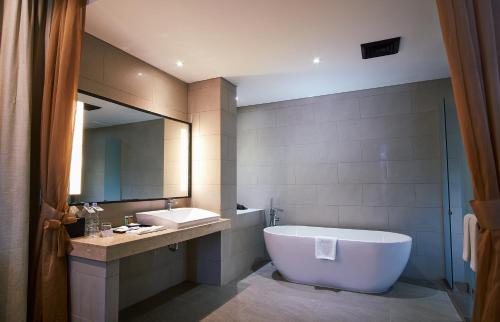 班达亚齐基里阿德姆拉雅阿策酒店的带浴缸、水槽和镜子的浴室
