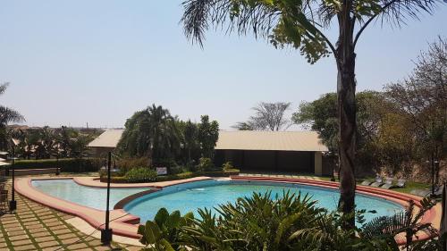 利隆圭Ufulu Gardens Hotel的棕榈树度假村的游泳池