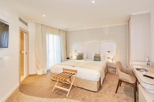 阿尔宗Appartements La Cigale的酒店客房设有一张大床和一张书桌。