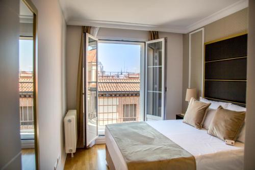 马德里TGH Gran Vía Apartments的一间卧室设有一张大床和一个大窗户