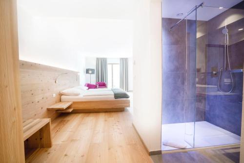 纳图尔诺Vegan Hotel La Vimea的浴室设有床铺和玻璃淋浴间。