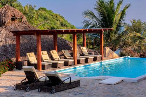 圣克鲁斯华特库鲁兹鲁纳别墅度假村的一组躺椅,位于游泳池旁