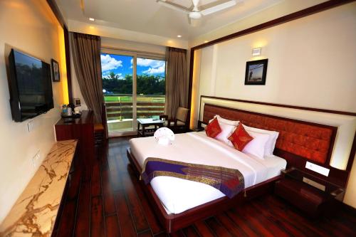 瓦拉纳西Comfort Inn Benares的一间卧室设有一张大床和一个大窗户
