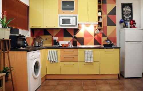 乌贝达Alojamiento Mercado de Abastos的厨房配有黄色橱柜和白色冰箱