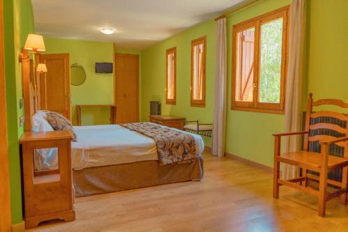 潘蒂科萨萨博科斯酒店的一间卧室设有绿色的墙壁、一张床和椅子