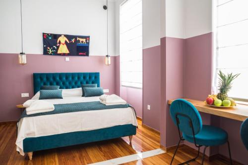 雅典Neratzia Rooms的一间卧室配有蓝色的床和一张书桌