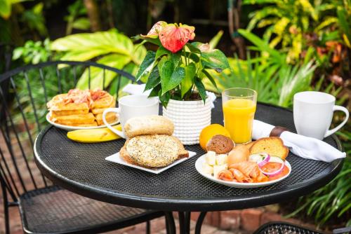 基韦斯特老镇庄园酒店的一张黑桌,上面放着早餐食品和橙汁