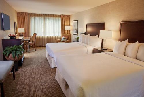 贝尔维尤Eastgate Hotel - BW Signature Collection的酒店客房配有两张床和一张书桌